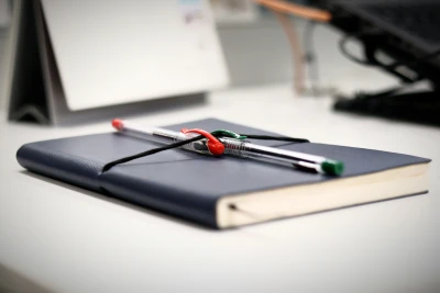 Pen resting on an open notebook manuscript